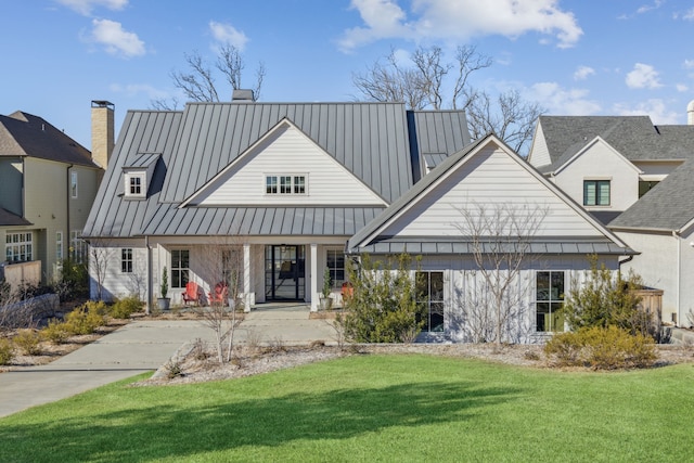 view of front of house featuring a standing seam roof, a front lawn, and metal roof