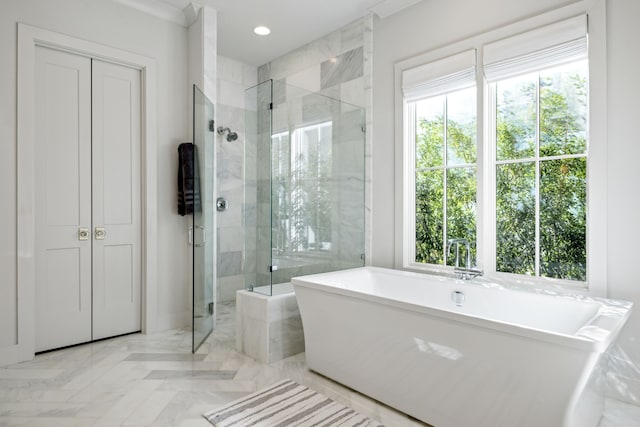 full bathroom featuring a healthy amount of sunlight, a soaking tub, a shower stall, and recessed lighting