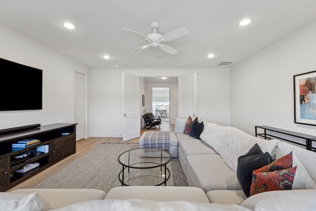 living area featuring light wood-style floors, visible vents, crown molding, and recessed lighting