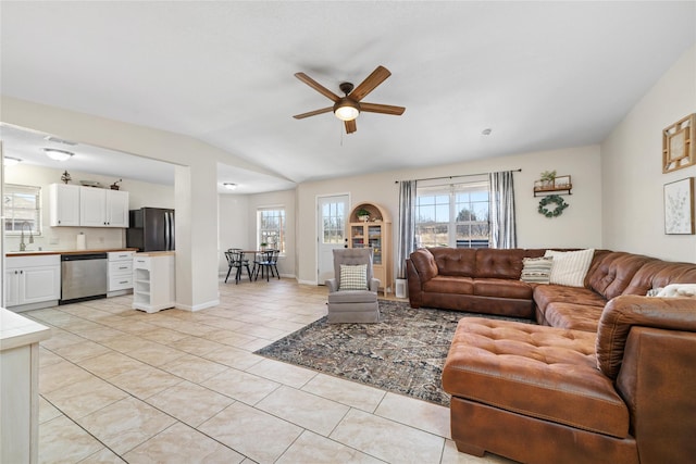 living area featuring light tile patterned floors, ceiling fan, vaulted ceiling, and a healthy amount of sunlight