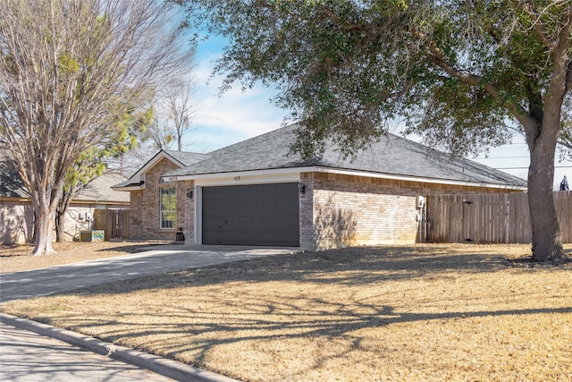 single story home with an attached garage, brick siding, a shingled roof, fence, and concrete driveway