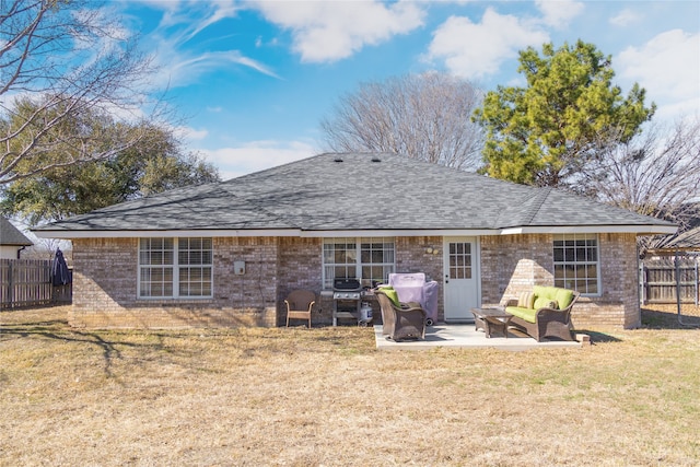 rear view of property with a yard, brick siding, fence, and a patio