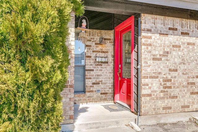 view of exterior entry featuring brick siding