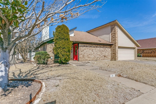 mid-century home with a garage, driveway, roof with shingles, and brick siding