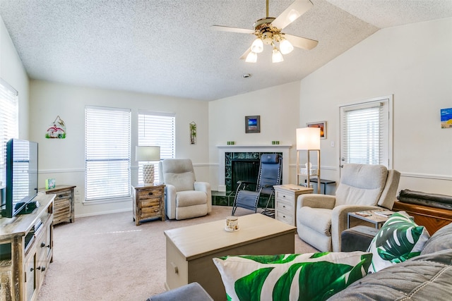 living room with vaulted ceiling, ceiling fan, carpet flooring, and a wealth of natural light