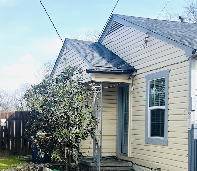 exterior space with a shingled roof and fence