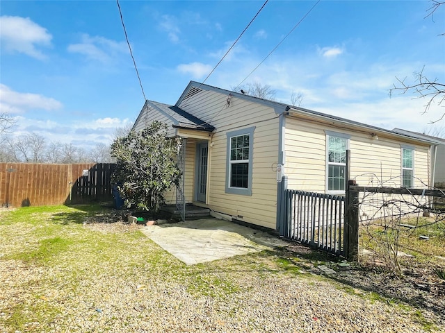 rear view of house with a patio, a yard, and fence