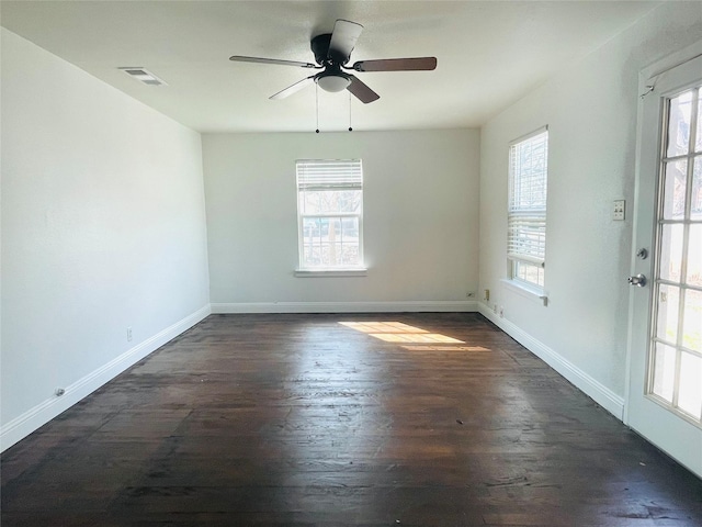 spare room with a ceiling fan, baseboards, visible vents, and dark wood-style flooring