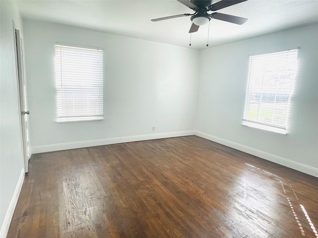 empty room featuring ceiling fan, baseboards, and wood finished floors