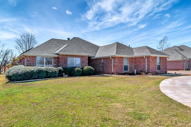 ranch-style house with a front yard, brick siding, and roof with shingles