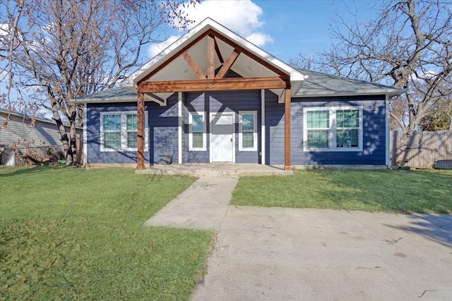 bungalow-style home with fence and a front lawn