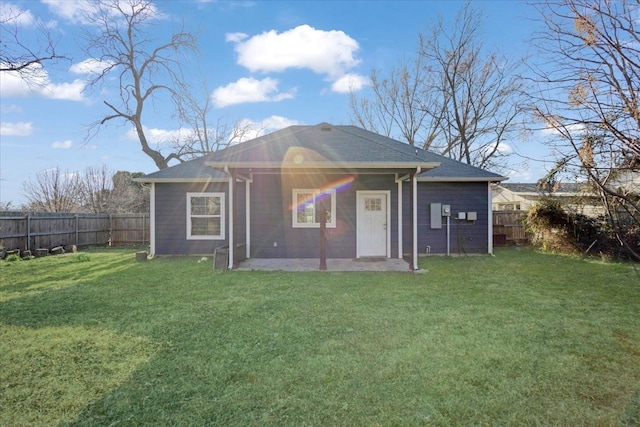 rear view of property featuring a patio, a lawn, and a fenced backyard