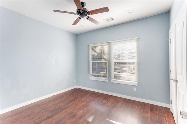 unfurnished room with a ceiling fan, visible vents, baseboards, and wood finished floors