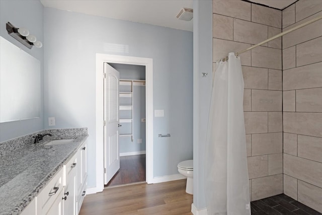 full bathroom featuring baseboards, visible vents, tiled shower, toilet, and wood finished floors