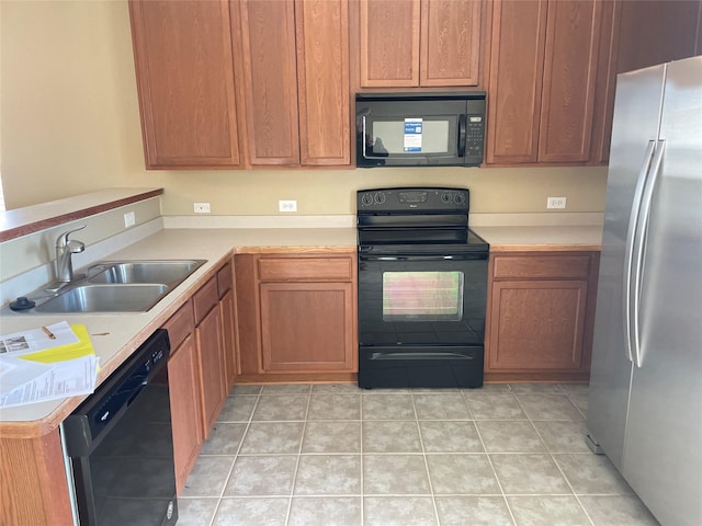 kitchen with light tile patterned floors, black appliances, a sink, and light countertops