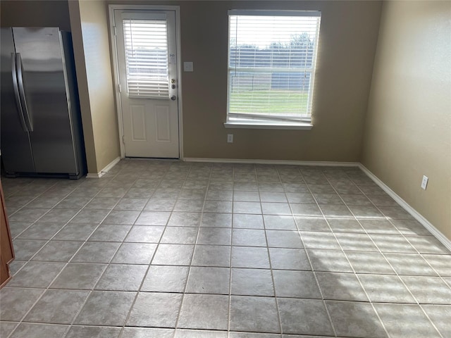 unfurnished dining area featuring baseboards and tile patterned floors