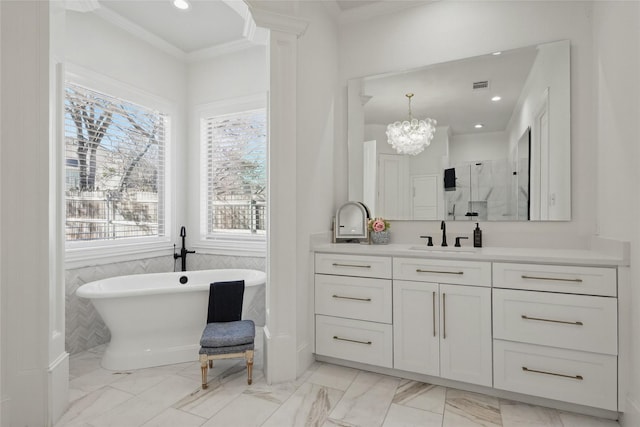 bathroom with marble finish floor, visible vents, ornamental molding, vanity, and a freestanding tub