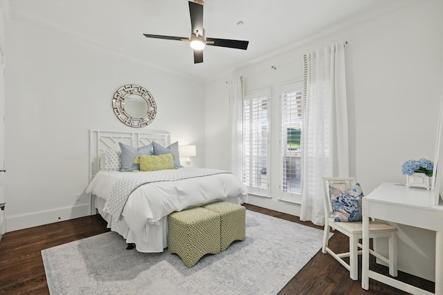 bedroom with a ceiling fan, crown molding, baseboards, and wood finished floors