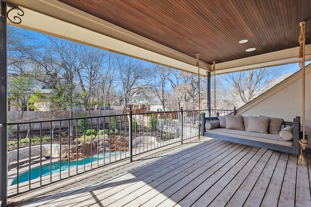 wooden terrace featuring fence and a fenced in pool