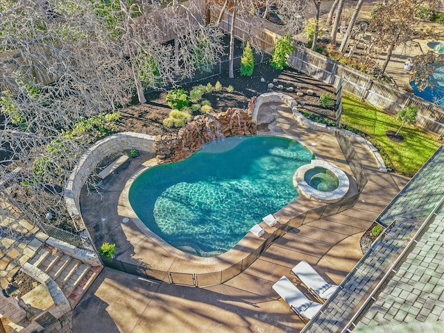 view of swimming pool with a pool with connected hot tub and a fenced backyard