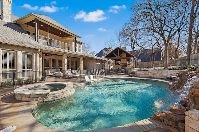 view of pool featuring a ceiling fan, fence, a gazebo, a patio area, and a pool with connected hot tub