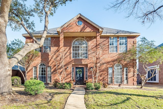 view of front of home with brick siding and a front lawn