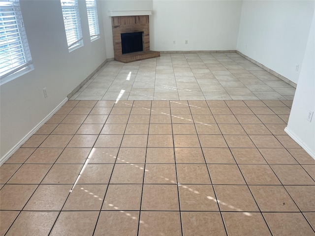 unfurnished living room featuring light tile patterned flooring and a fireplace