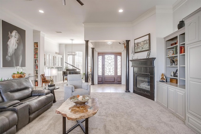 living room with recessed lighting, light colored carpet, ornate columns, a glass covered fireplace, and crown molding