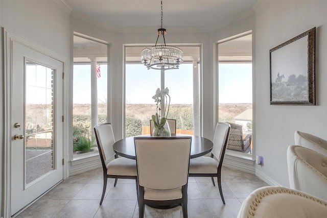 dining area with light tile patterned floors, a notable chandelier, baseboards, and crown molding