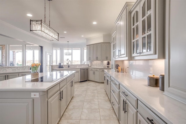 kitchen featuring black electric stovetop, a sink, light countertops, decorative backsplash, and glass insert cabinets