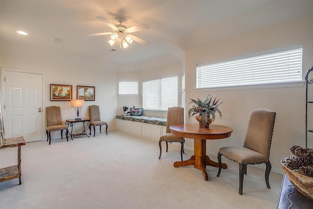 living area featuring light carpet, ceiling fan, and visible vents