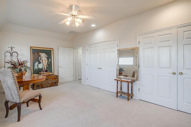 living area featuring ceiling fan, carpet flooring, and visible vents