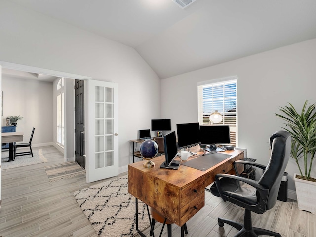 home office featuring visible vents, baseboards, lofted ceiling, french doors, and light wood-type flooring