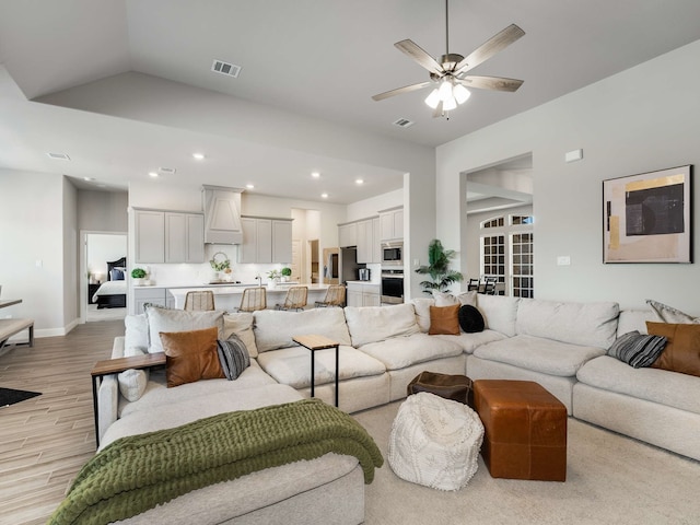 living area featuring light wood finished floors, visible vents, ceiling fan, vaulted ceiling, and recessed lighting