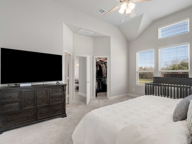 bedroom with lofted ceiling, a spacious closet, visible vents, and light colored carpet