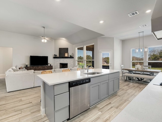 kitchen with gray cabinetry, a sink, a ceiling fan, visible vents, and dishwasher