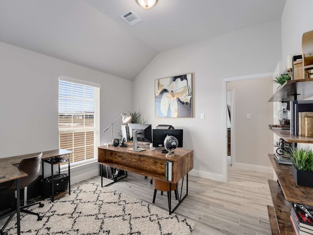 office featuring baseboards, visible vents, vaulted ceiling, and wood finished floors