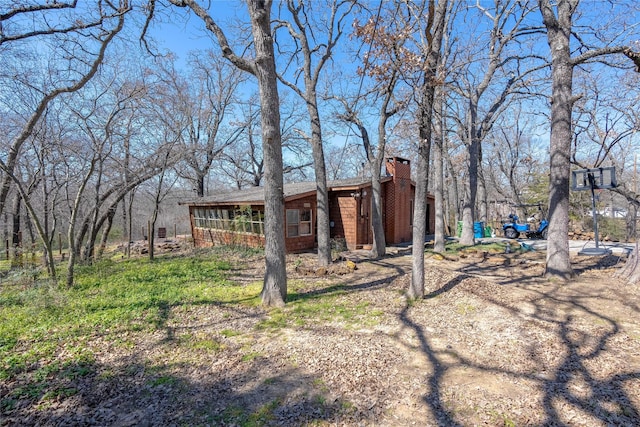 exterior space featuring a chimney and a sunroom