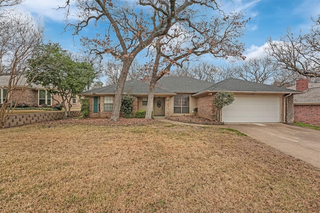 single story home with a garage, concrete driveway, a front lawn, and brick siding