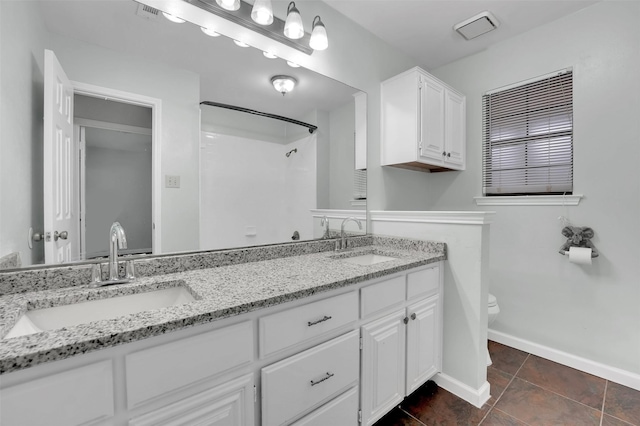 bathroom featuring a shower, baseboards, a sink, and toilet