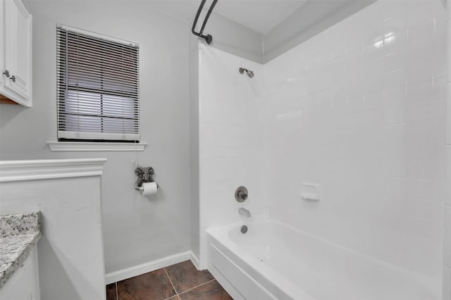 bathroom with washtub / shower combination, tile patterned flooring, vanity, and baseboards