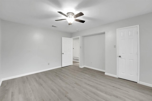 unfurnished bedroom with baseboards, visible vents, a ceiling fan, wood finished floors, and a closet