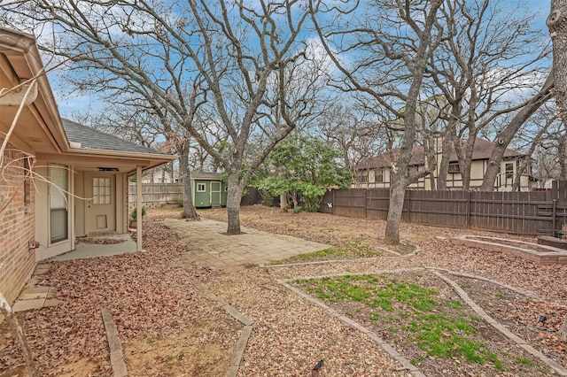 view of yard featuring an outbuilding, a patio area, and a fenced backyard