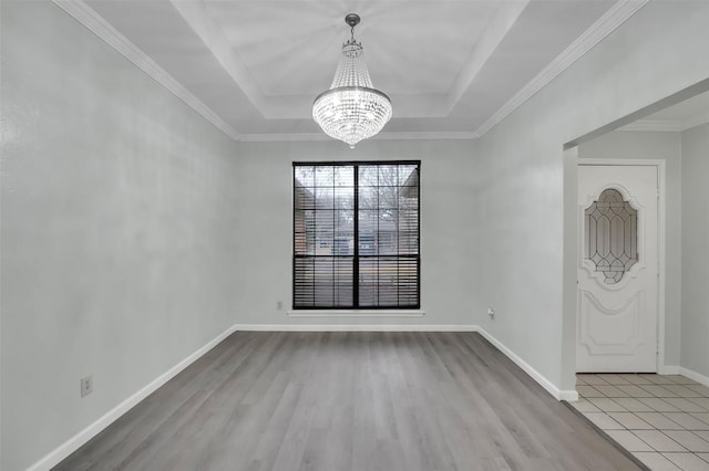 entryway with an inviting chandelier, baseboards, a tray ceiling, and wood finished floors