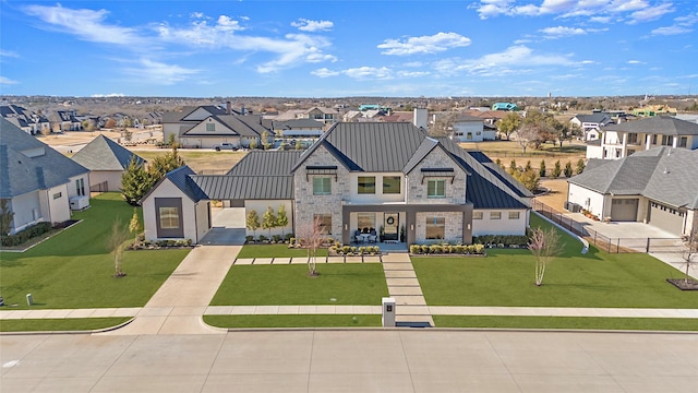 view of front of home featuring a residential view, a standing seam roof, metal roof, and a front lawn