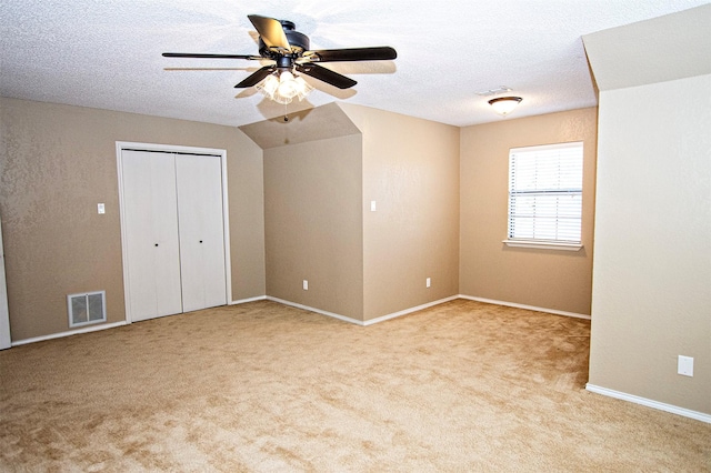 unfurnished bedroom featuring light carpet, visible vents, and a textured ceiling