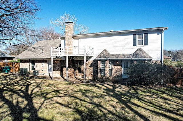 back of property with a patio area, a lawn, a chimney, and fence