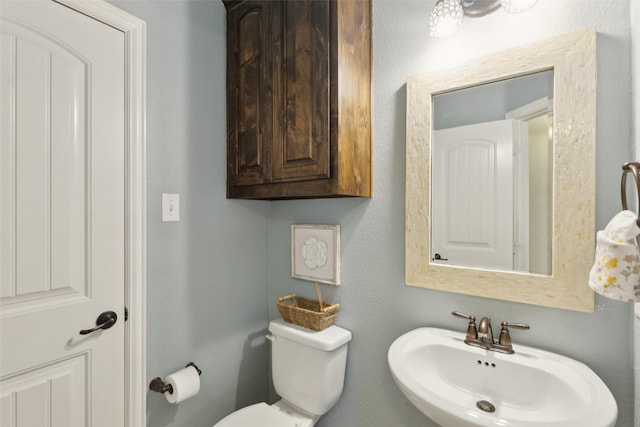 half bath featuring a sink and toilet