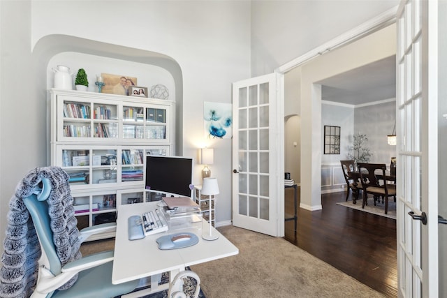 office space featuring arched walkways, wood finished floors, crown molding, and french doors