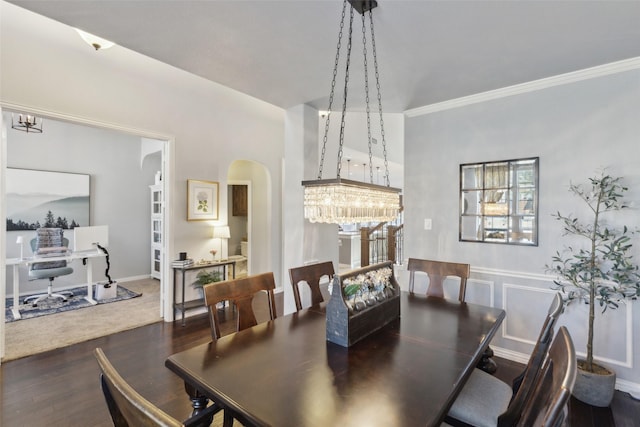 dining space featuring crown molding, arched walkways, and wood finished floors